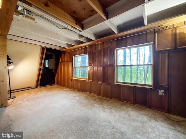 spare room featuring light colored carpet and wooden walls