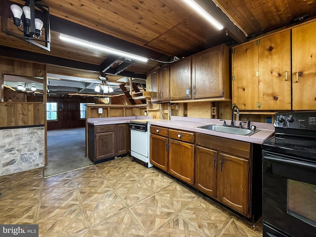 kitchen with a sink, light countertops, ceiling fan, wooden walls, and electric range