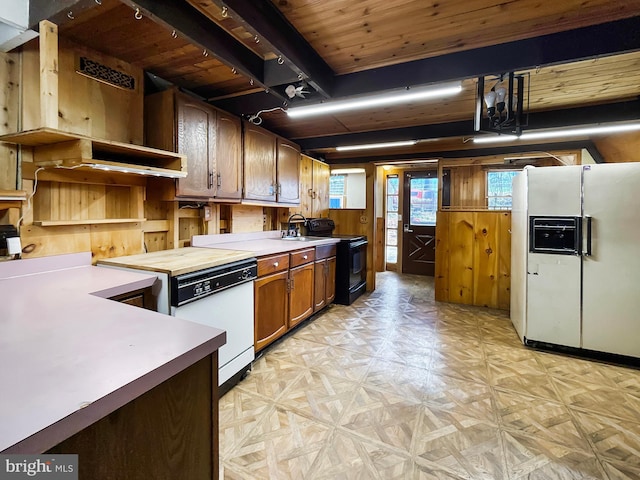 kitchen featuring wooden ceiling, light countertops, white appliances, wooden walls, and light floors