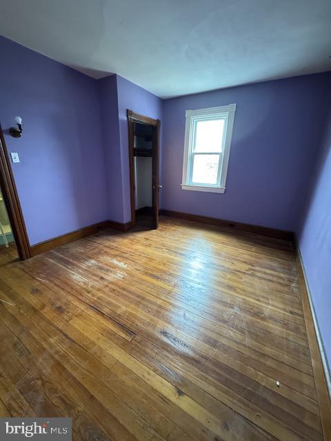 unfurnished bedroom with wood-type flooring and baseboards