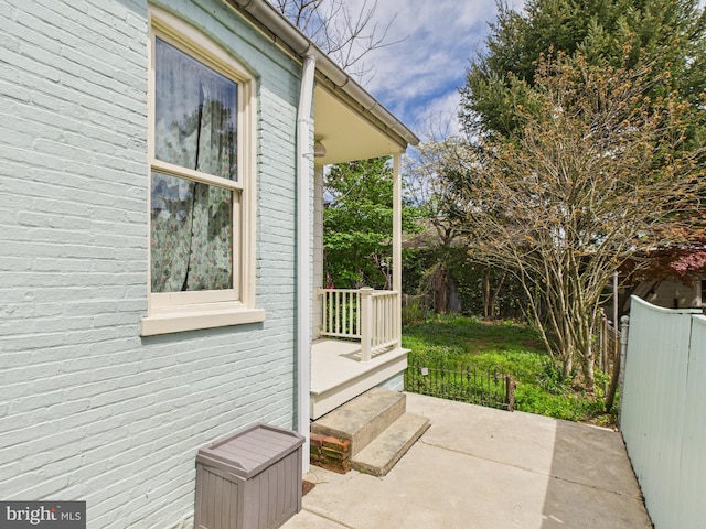 view of side of home featuring fence and a patio