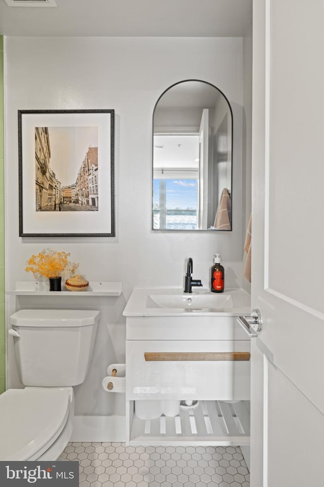 bathroom with toilet, visible vents, tile patterned flooring, and vanity