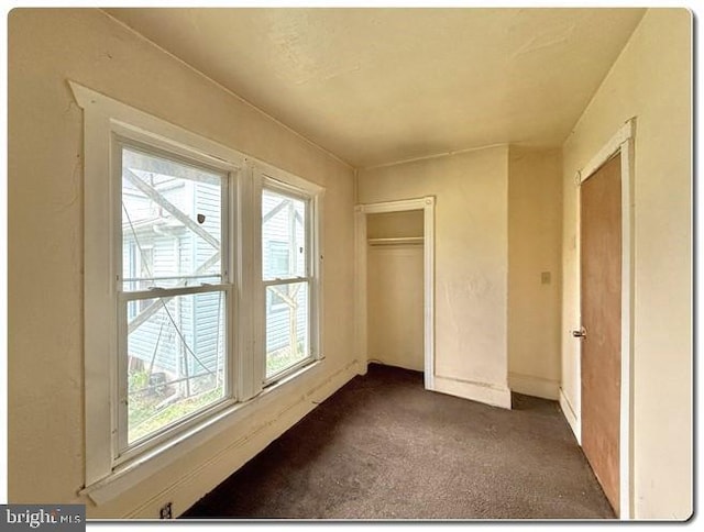 207 S 4th St, Millville, NJ 08332 - unfurnished bedroom featuring dark carpet, a closet, baseboards, and multiple windows