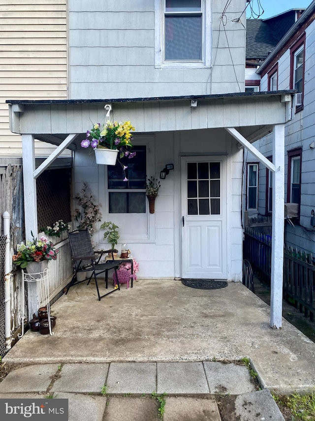 entrance to property featuring fence and a porch