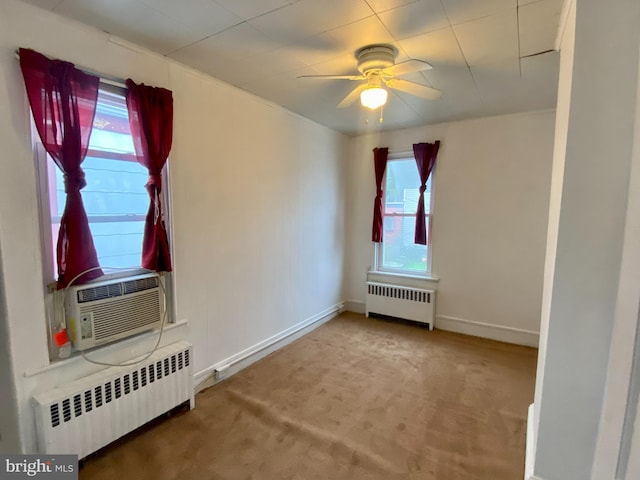 unfurnished room featuring carpet floors, ceiling fan, baseboards, and radiator