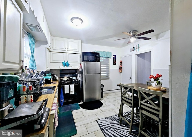 801 Spruce St, Trenton, NJ 08638 - kitchen featuring range hood, white cabinetry, a ceiling fan, black appliances, and baseboard heating