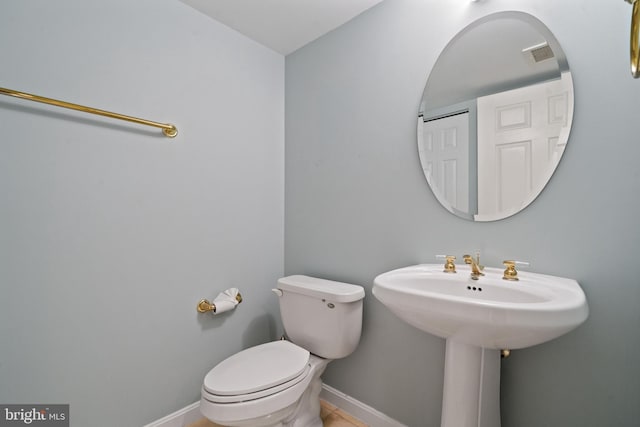 bathroom featuring baseboards and toilet