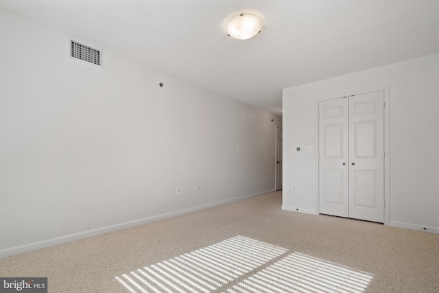 unfurnished bedroom with carpet, a closet, and baseboards
