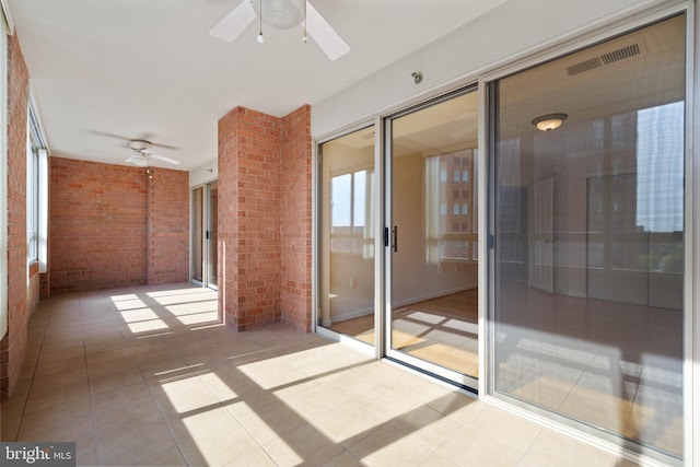 unfurnished sunroom with ceiling fan