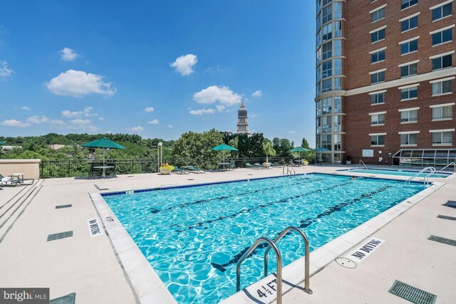 community pool featuring fence and a patio area