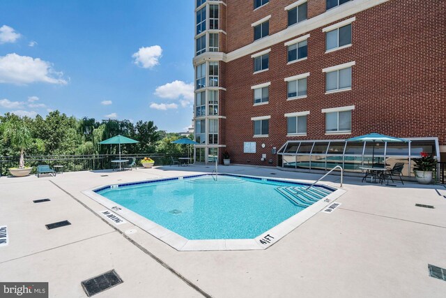 community pool featuring fence and a patio area