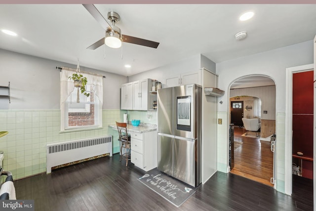 kitchen with radiator, arched walkways, a ceiling fan, wainscoting, and smart refrigerator