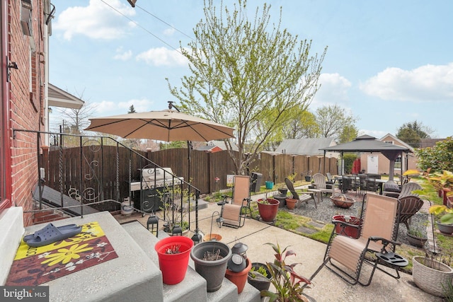 view of patio with a gazebo, a fire pit, and a fenced backyard