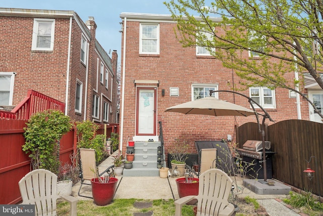 back of property with brick siding and fence