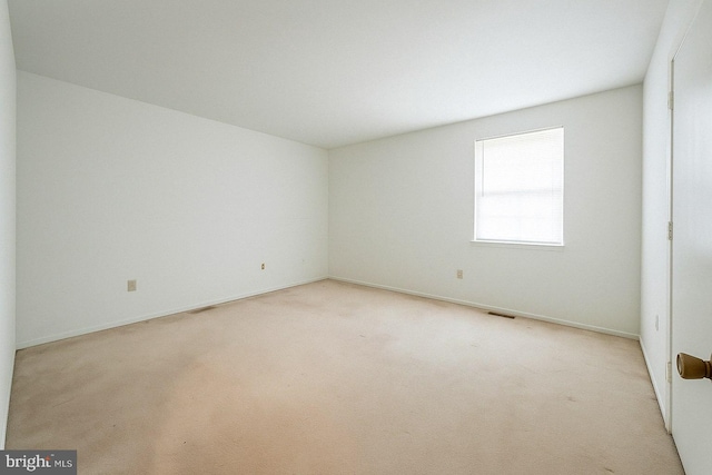 empty room with light carpet, visible vents, and baseboards
