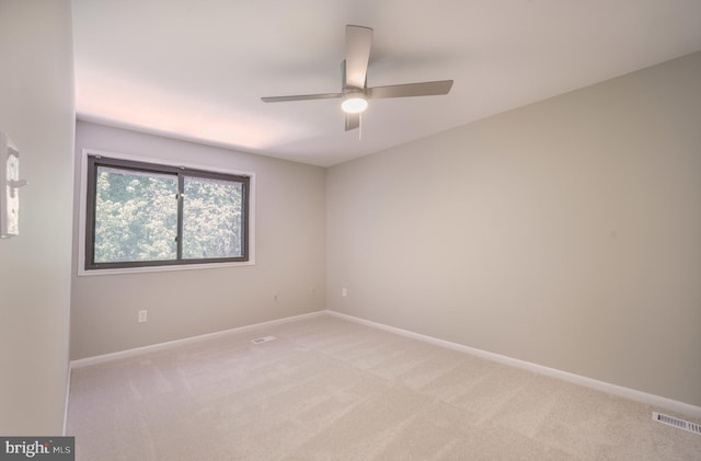 unfurnished room featuring visible vents, a ceiling fan, baseboards, and light carpet