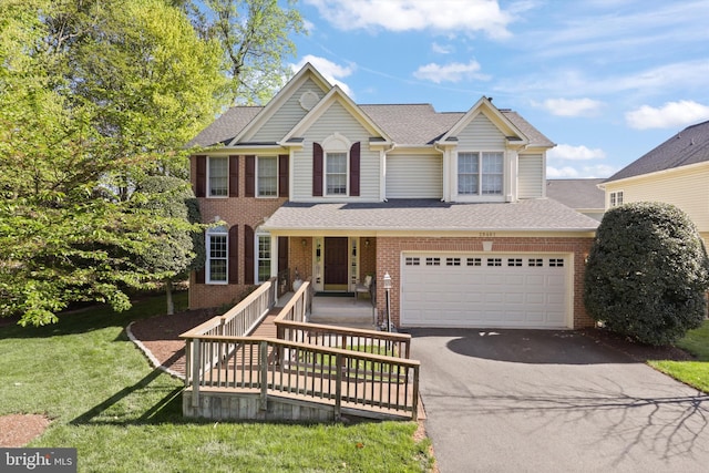 traditional home with driveway, brick siding, a garage, a front yard, and a shingled roof