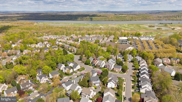 aerial view of property's location with a large body of water, nearby suburban area, and a local golf course