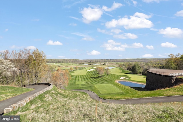 drone / aerial view of a nearby body of water and a golf course
