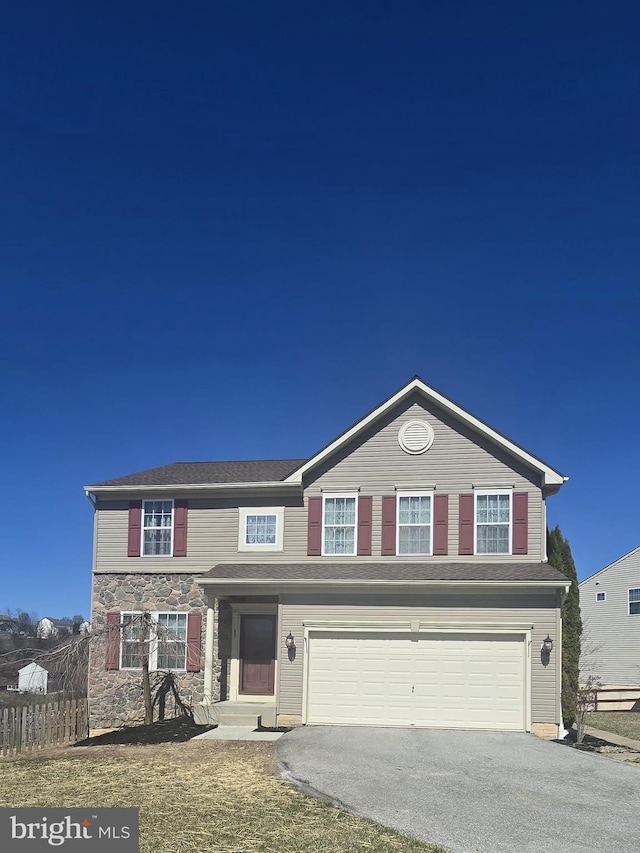 traditional home featuring an attached garage, aphalt driveway, and stone siding