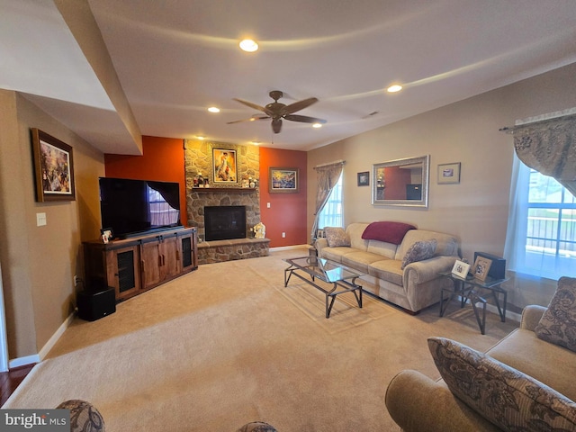 living area with carpet, a ceiling fan, a stone fireplace, recessed lighting, and baseboards