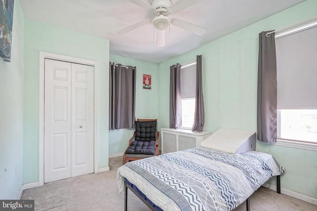 bedroom featuring ceiling fan, baseboards, a closet, and carpet