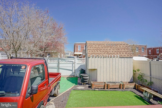 view of yard featuring an outbuilding, a shed, and a fenced backyard