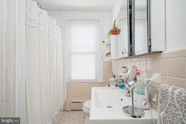 bathroom with tile walls, tile patterned floors, and baseboard heating