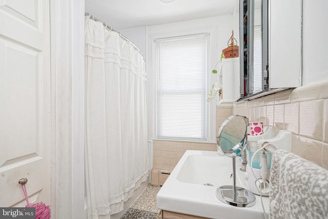 full bathroom with baseboard heating and tile walls