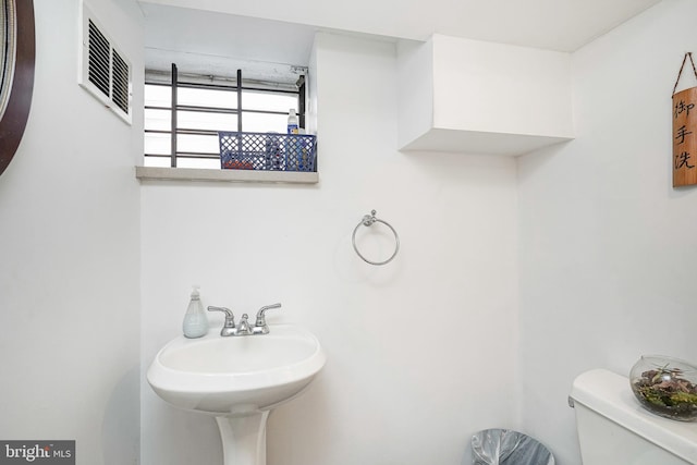 bathroom with visible vents, a sink, and toilet