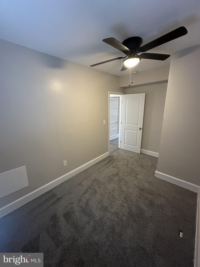 spare room featuring baseboards, ceiling fan, and carpet