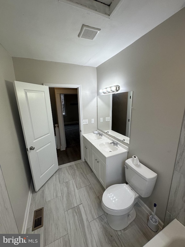 bathroom with double vanity, visible vents, and a sink