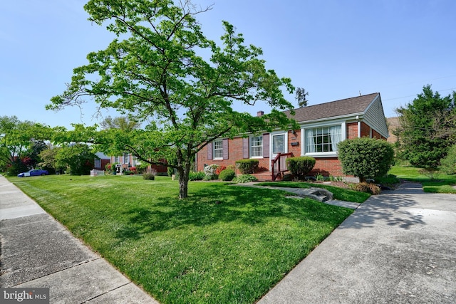 single story home with brick siding, a chimney, and a front yard