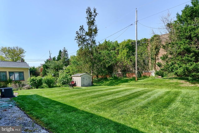 view of yard with a storage shed, an outbuilding, and central AC unit