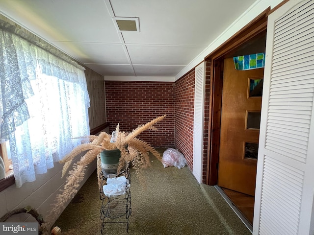 carpeted dining area with brick wall