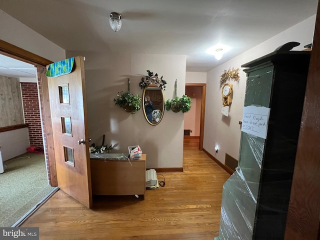 hallway featuring baseboards and light wood-style floors