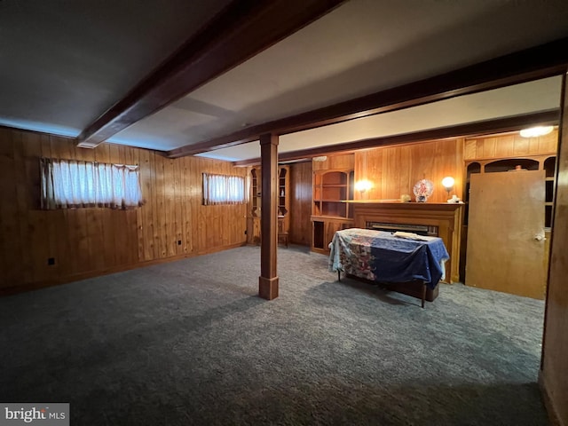 basement featuring a fireplace, wood walls, and carpet