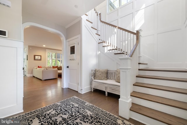 entryway featuring arched walkways, recessed lighting, stairway, and dark wood-type flooring