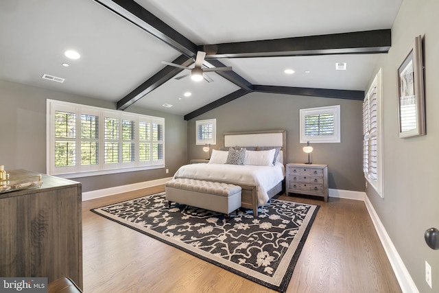 bedroom with baseboards, visible vents, multiple windows, and wood finished floors