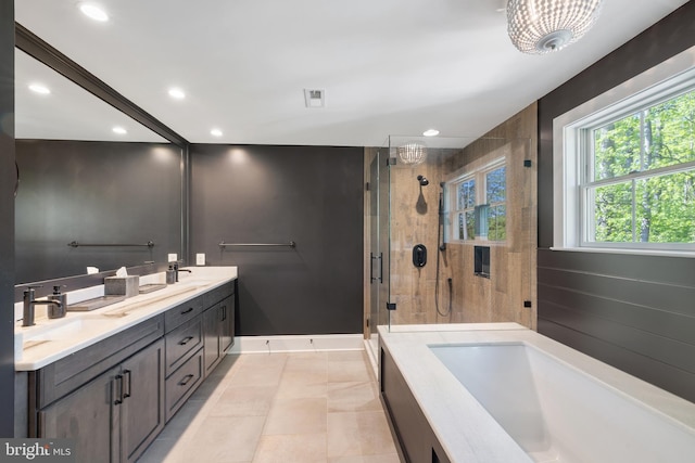 bathroom featuring a garden tub, double vanity, recessed lighting, a shower stall, and a sink