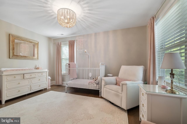 bedroom with a chandelier and dark wood finished floors