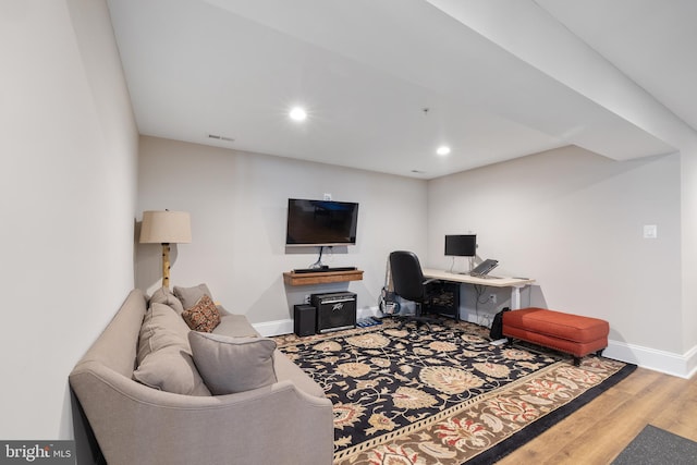 office space featuring baseboards, recessed lighting, wood finished floors, and visible vents