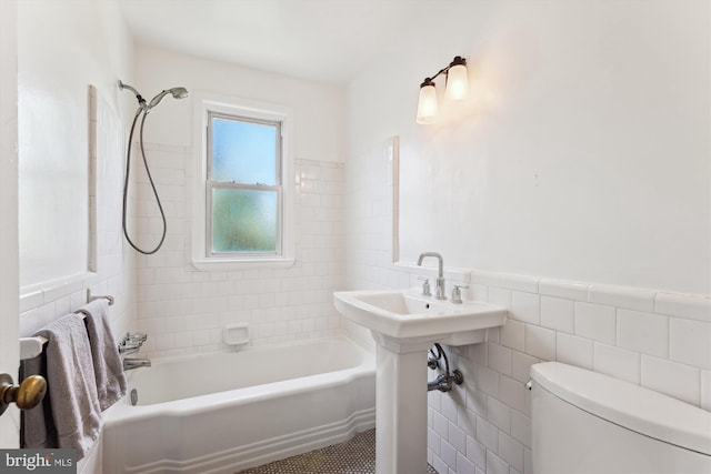 bathroom featuring shower / bath combination, tile walls, wainscoting, and toilet