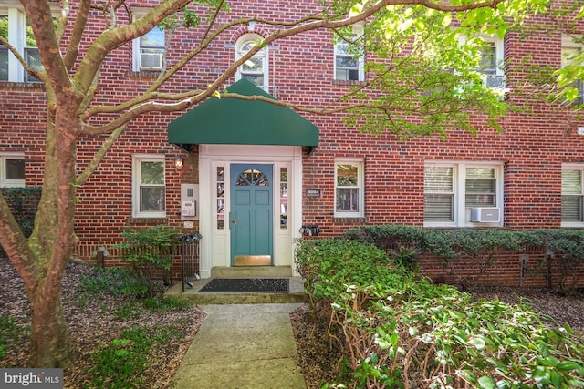 entrance to property with brick siding and cooling unit