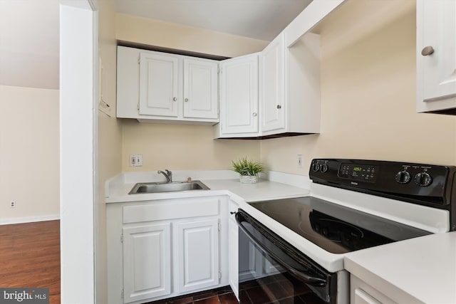 kitchen featuring white cabinets, a sink, range with electric stovetop, and light countertops