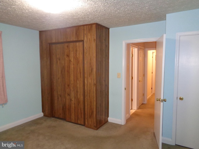 additional living space with a textured ceiling, carpet floors, and baseboards