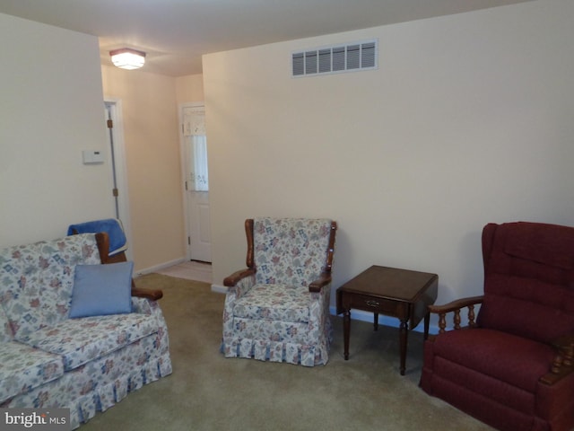 living area with visible vents and carpet