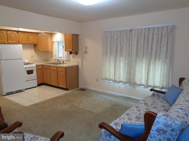 kitchen with white appliances, light countertops, light carpet, a sink, and baseboards