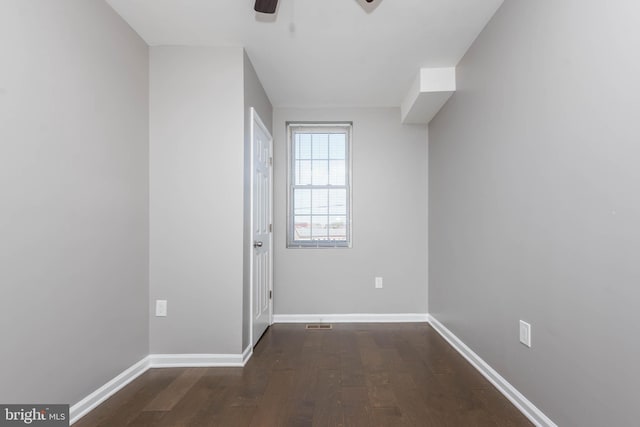 empty room with ceiling fan, baseboards, and wood finished floors