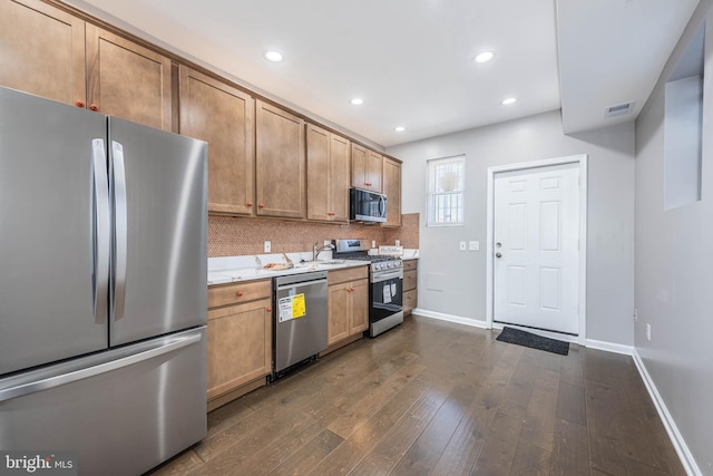 kitchen with baseboards, recessed lighting, dark wood-style floors, light countertops, and appliances with stainless steel finishes